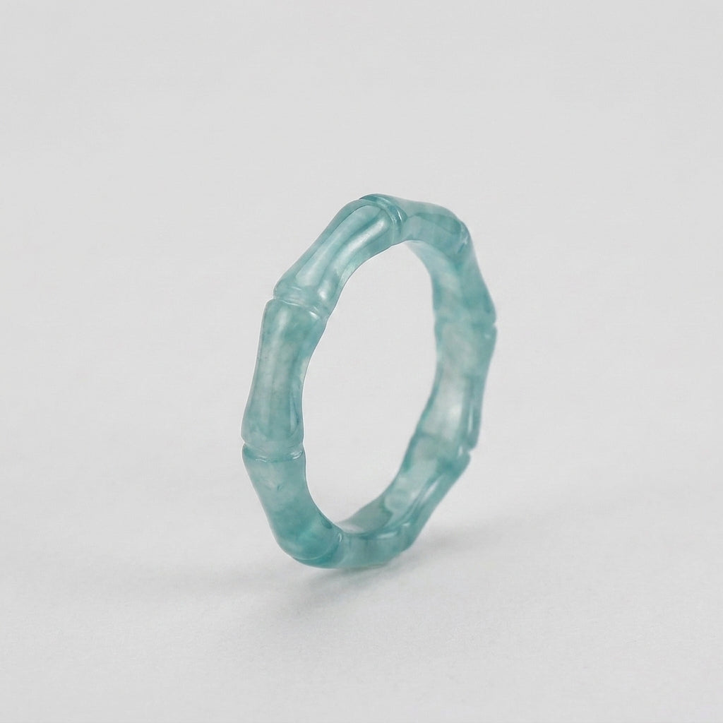 A light blue jade ring shaped like bamboo segments, photographed on a plain white background.