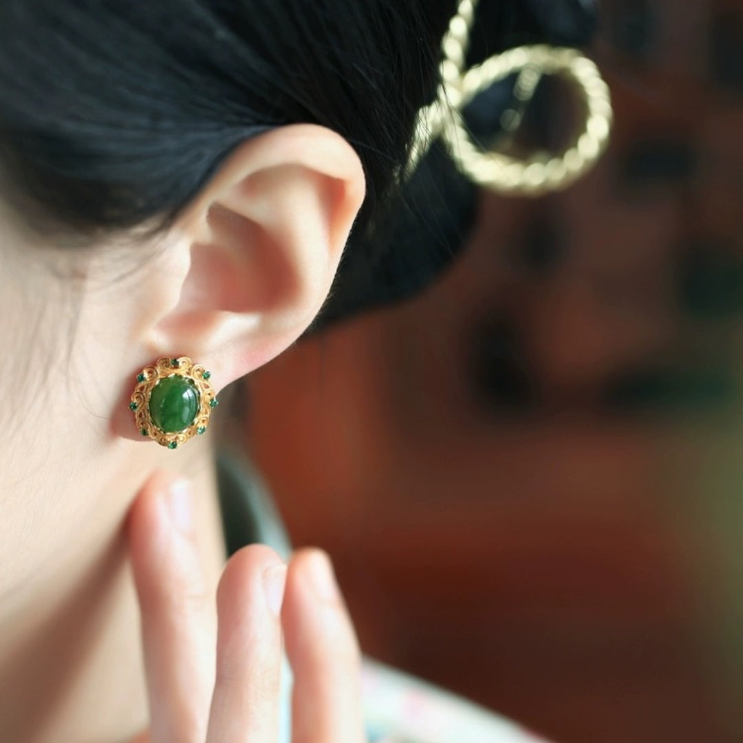 Close-up of a woman wearing Charmed Green Jade Cloud Stud Earrings with intricate gold detailing and small emerald accents.