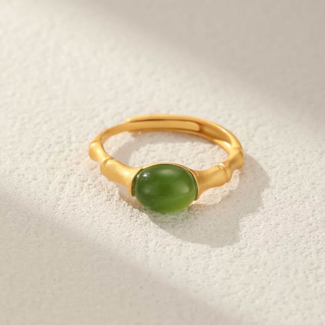 Gold-plated silver ring with a bamboo design and a smooth, oval green jade stone.