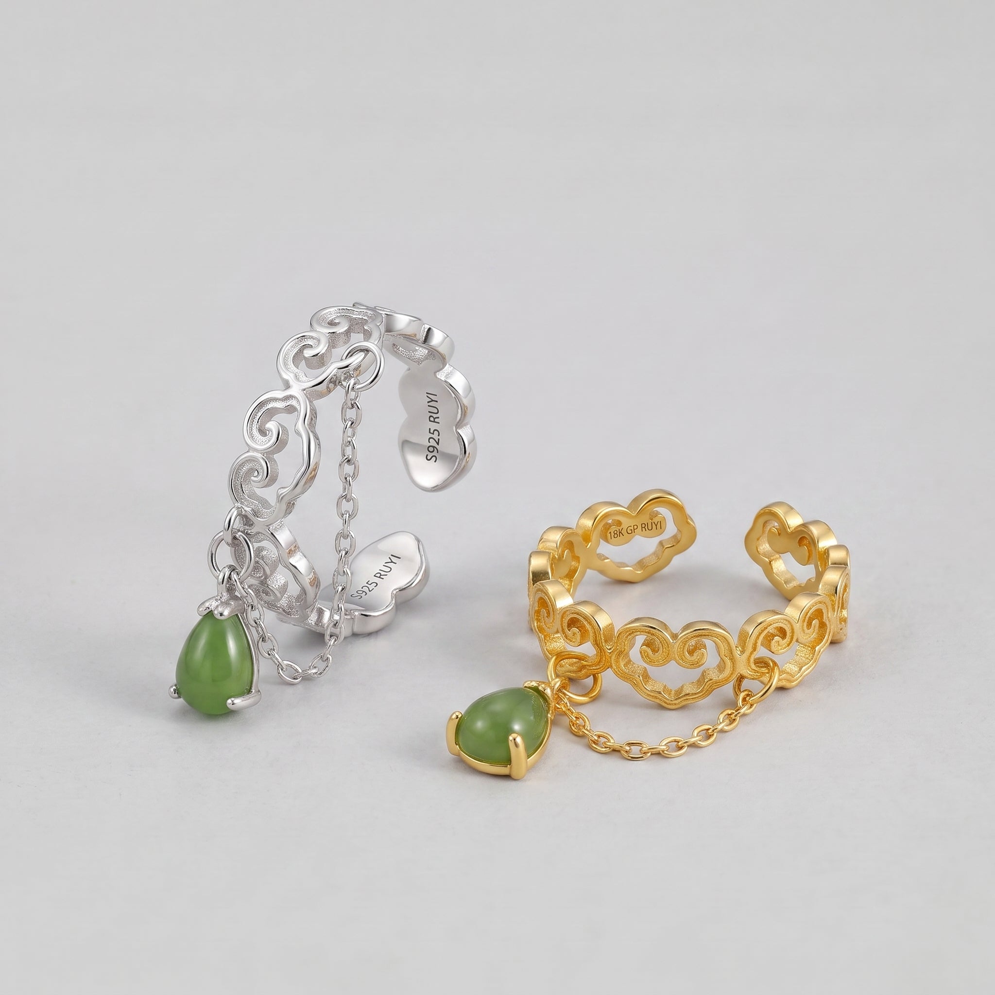 Two adjustable rings with cloud motifs, one silver and one gold-plated, each featuring a dangling teardrop-shaped green jade stone.