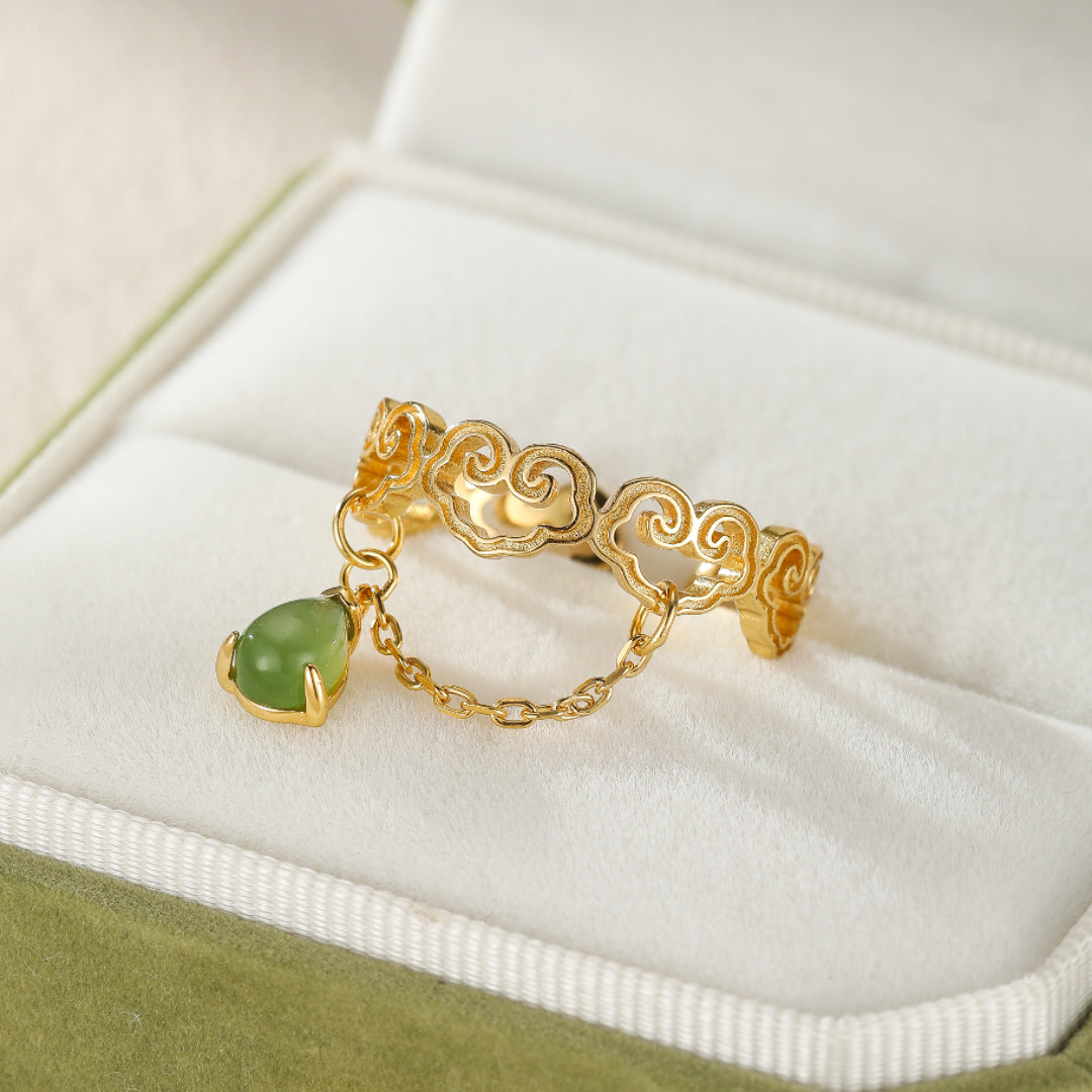 Heaven's Favor Hetian Jade Cloud Ring with a dangling pear-shaped green jade stone and gold chain detail.