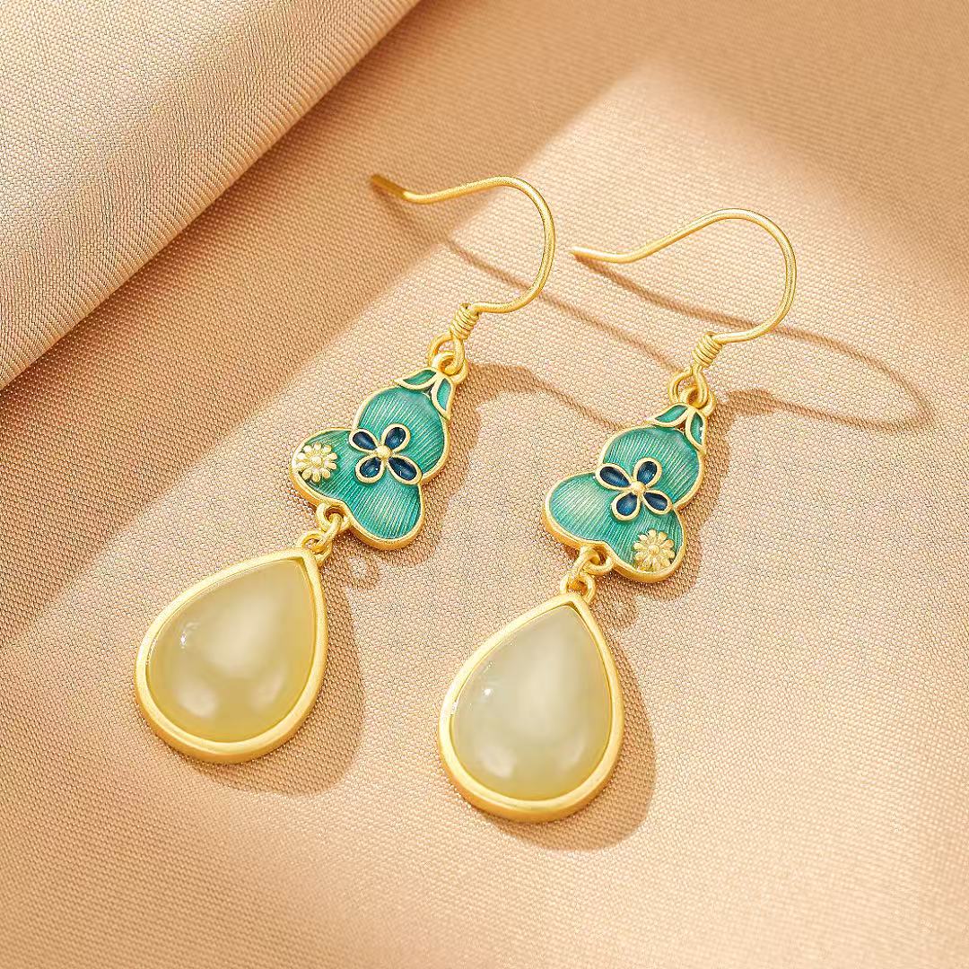 Gold-plated silver earrings featuring teardrop-shaped jade pendants and ornate teal gourd charms with floral details.