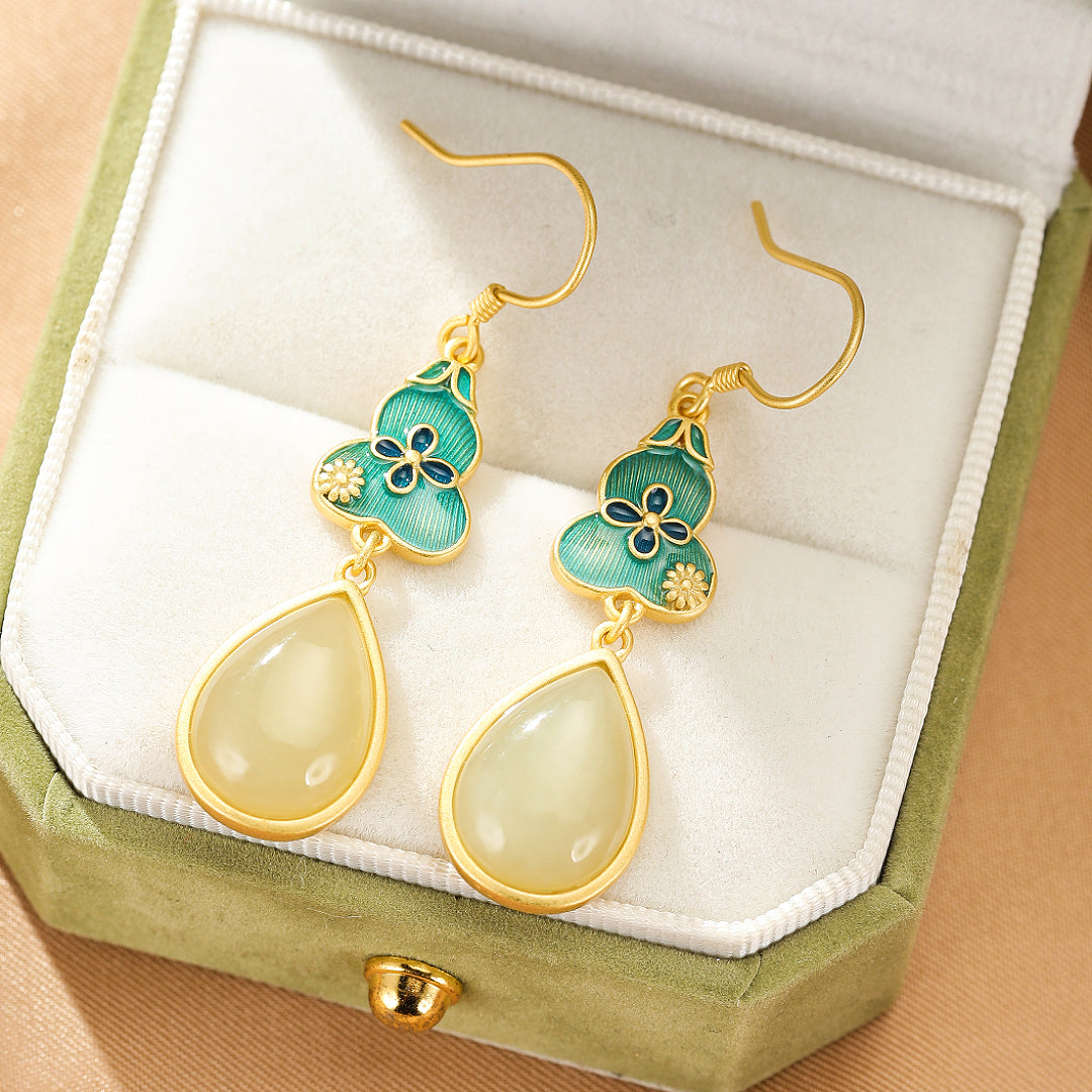 Gold-plated silver drop earrings featuring carved turquoise gourd charms with blue floral accents and pear-shaped jade pendants.