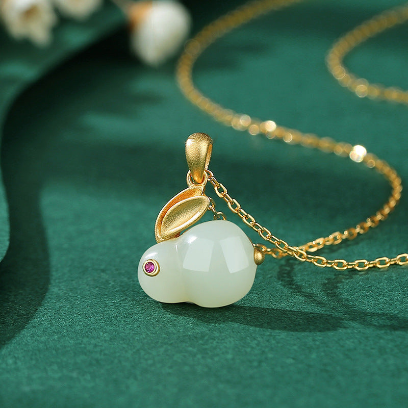Moonglow - Hetian Jade Rabbit Pendant Necklace with gold-plated silver chain and ruby accent.