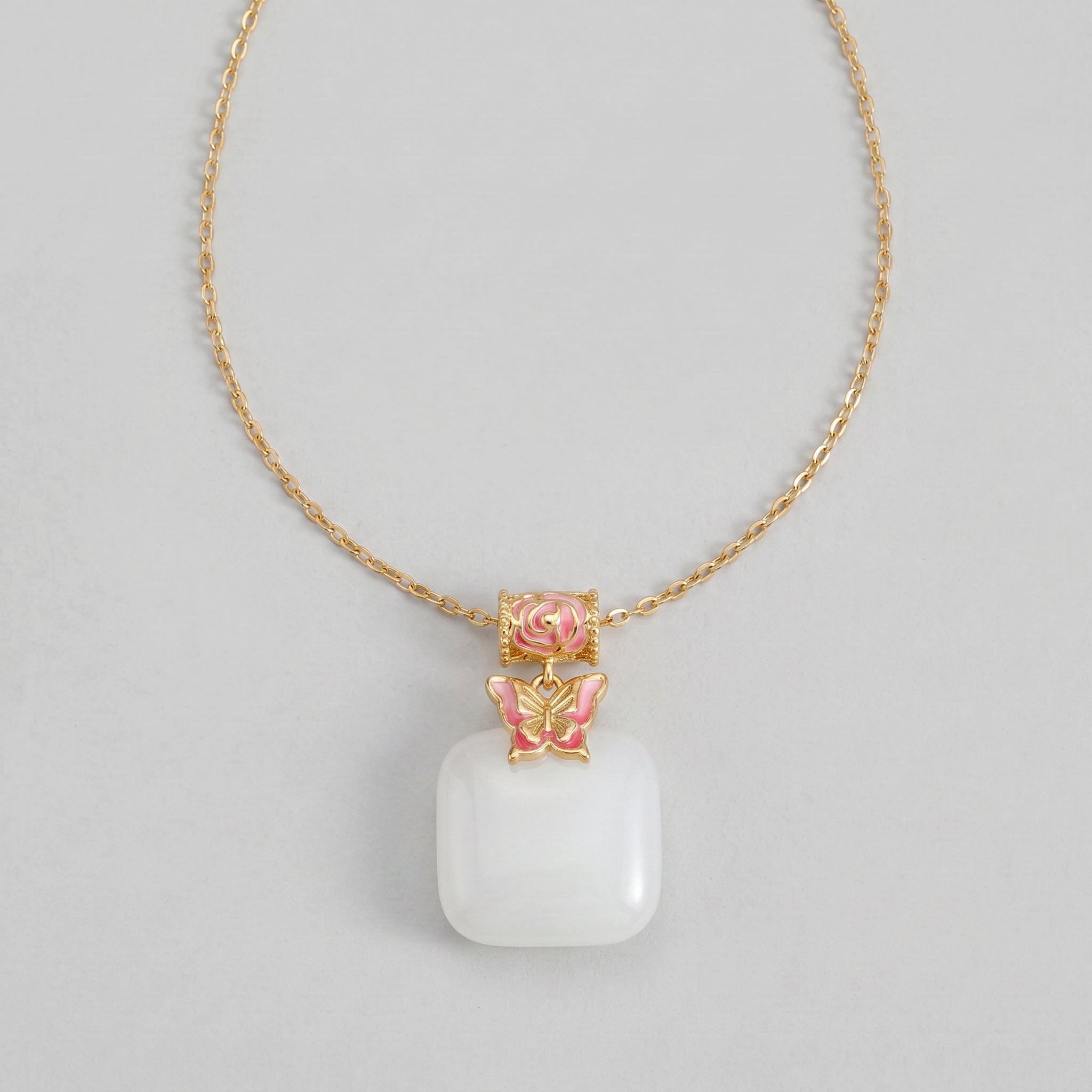 Second Act Mutton Fat Jade Butterfly Pendant Necklace with a gold chain and pink enamel details on a grey background.