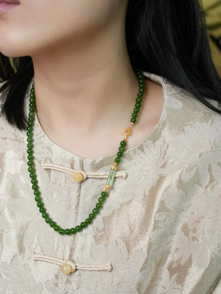 woman wearing a dark green jade bead necklace