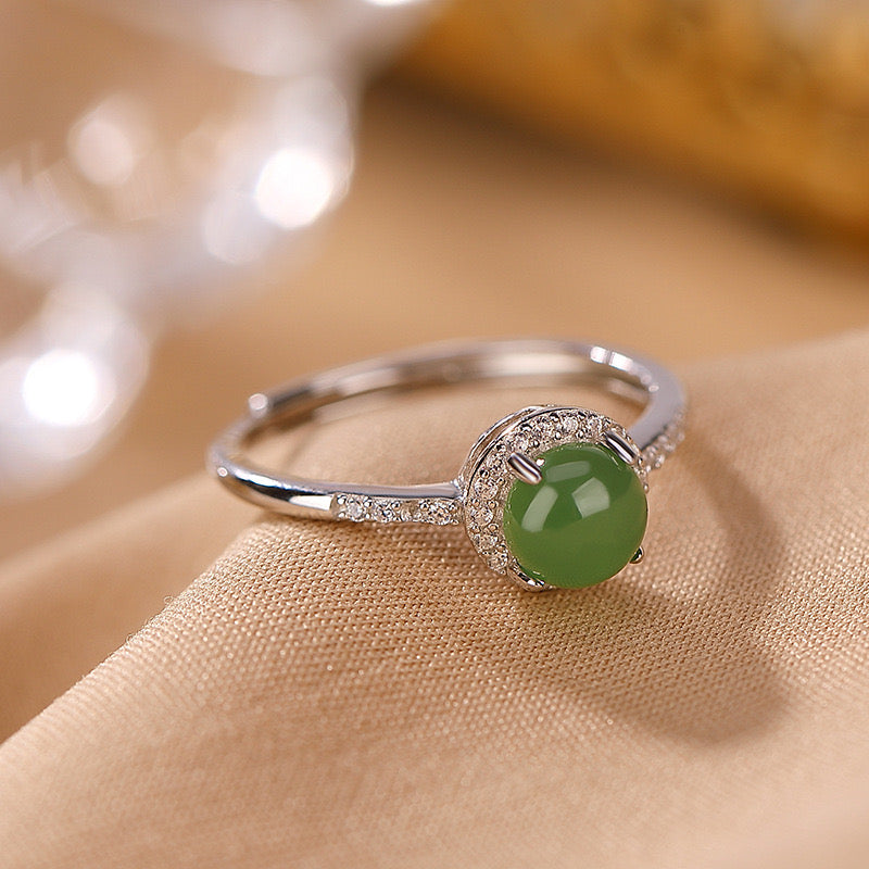 Answered — Green Jade Solitaire Ring with a halo of small clear stones on a silver band.