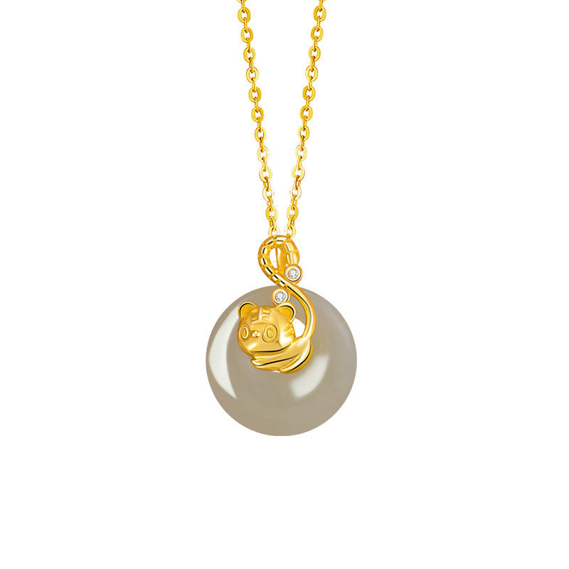 Birthright - A golden tiger pendant with diamond accents dangles from a gold chain, embracing a smooth, pale grey Hetian jade disc.