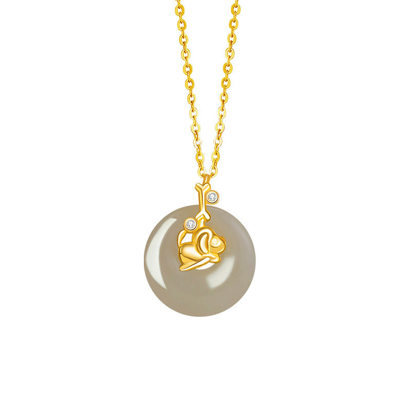 Birthright Hetian Jade Zodiac Pendant Necklace featuring a golden rabbit charm and two small diamonds on a grey jade disc pendant with a gold chain.