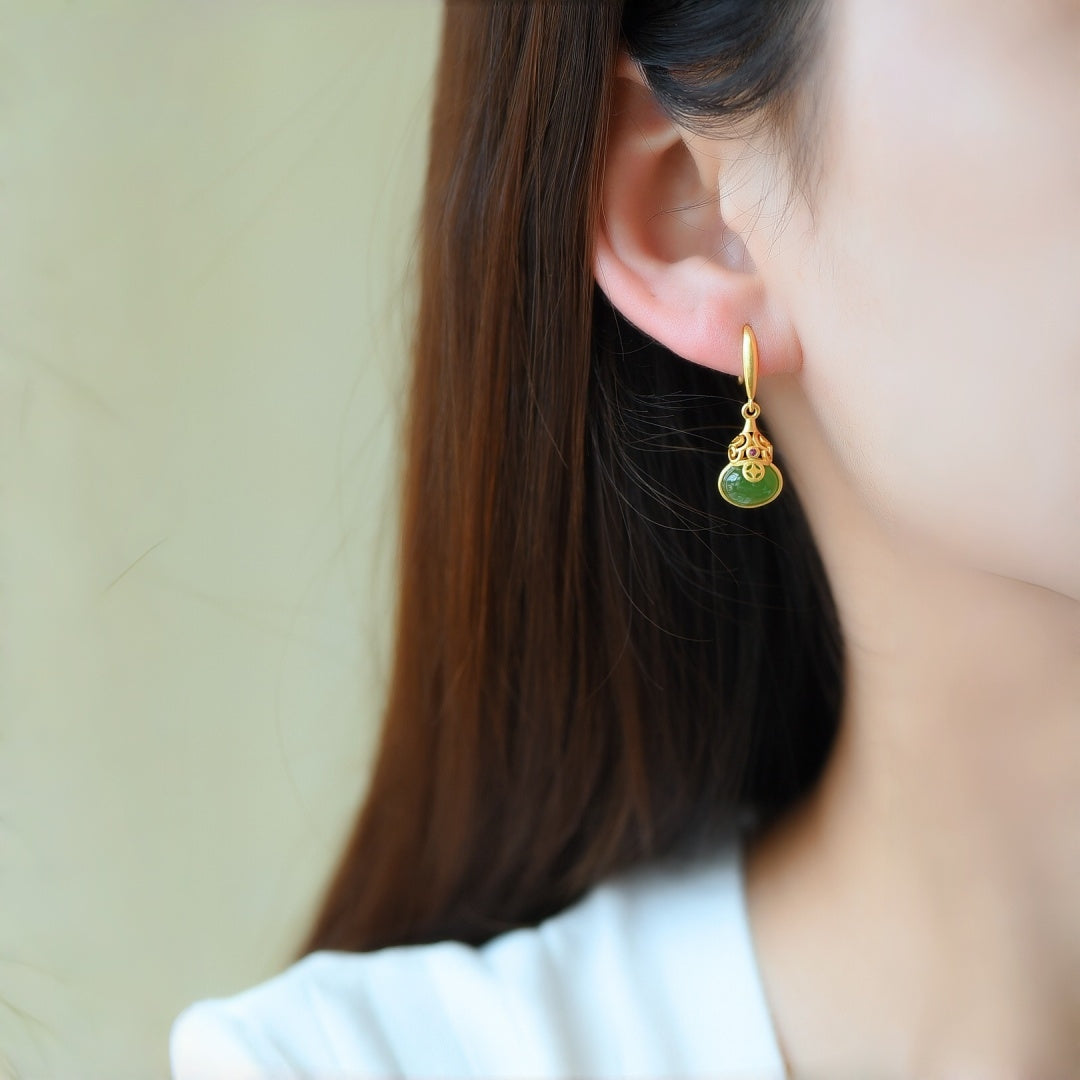 Brimful Green Jade Gourd Drop Earrings with gold accents on a model's ear.