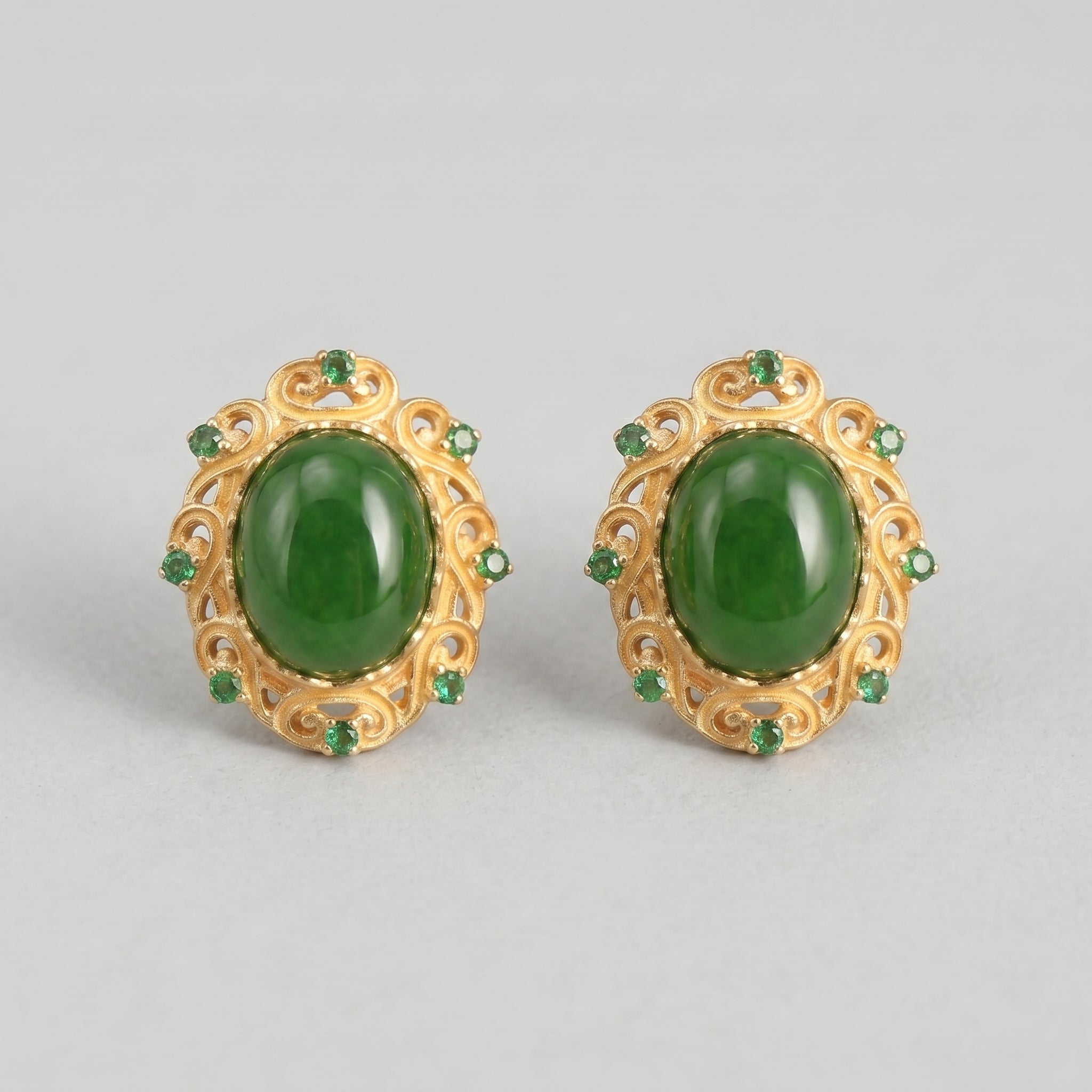 Charmed Green Jade Cloud Stud Earrings with ornate gold settings and small green accent stones.