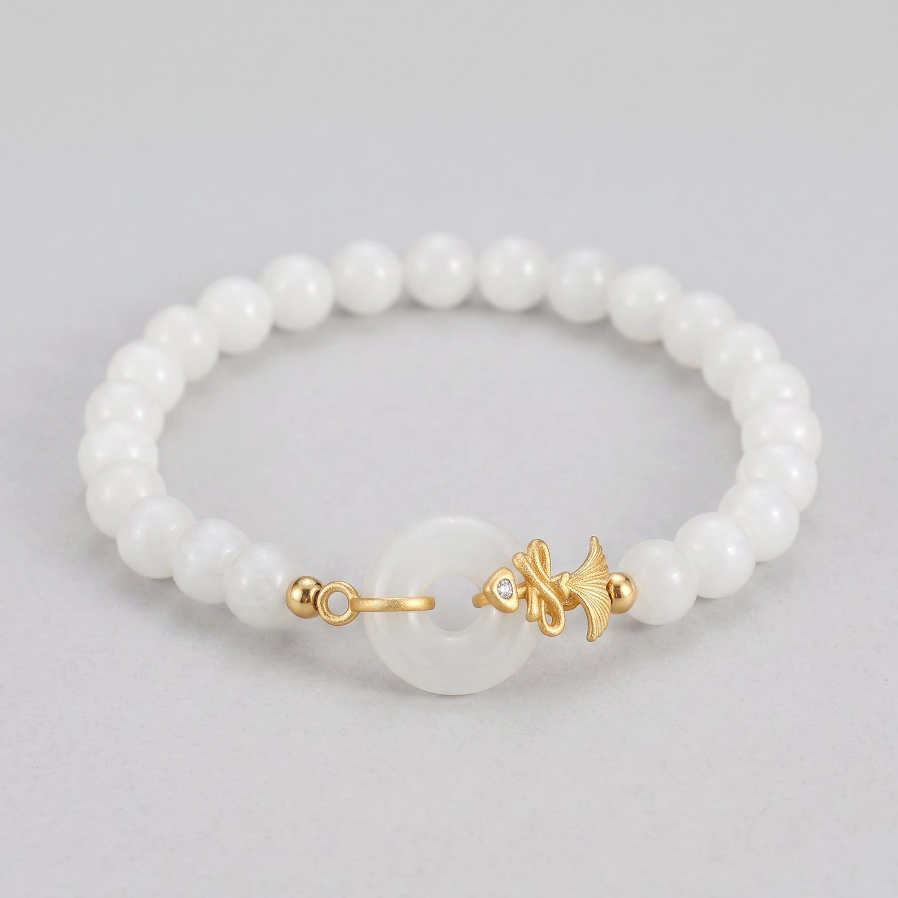 Charmed Life white Hetian jade Bi disc beaded bracelet with a golden fish charm and a small diamond accent.