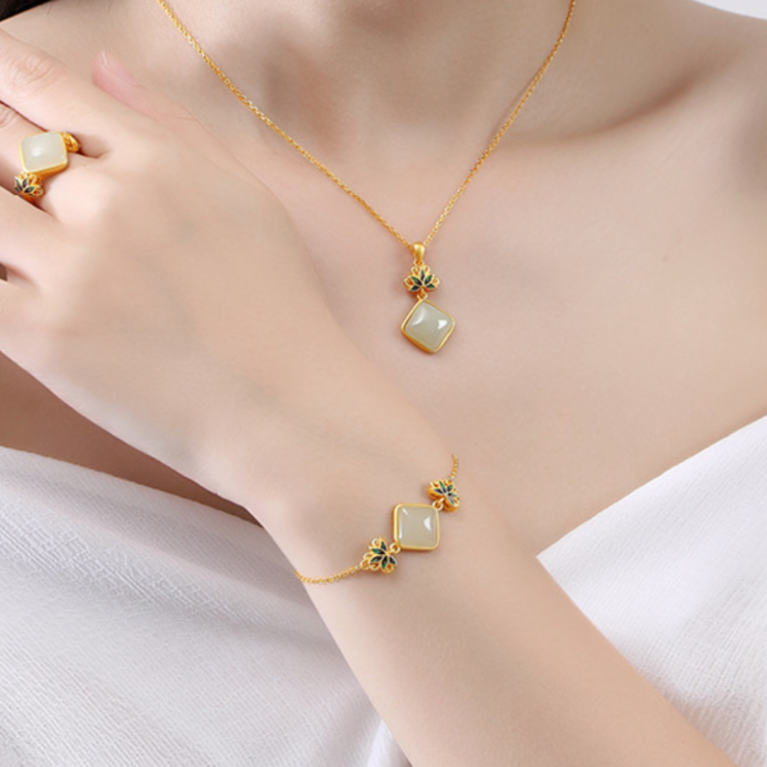 Ease Hetian Jade Lotus Bracelet featuring square jade pendants and green lotus accents on a delicate gold chain.