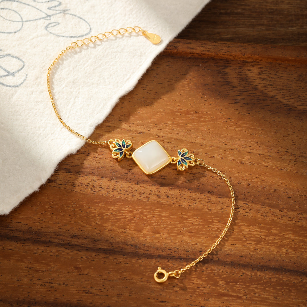 Ease Hetian Jade Lotus Bracelet with a square white jade centerpiece and blue lotus flower accents on a gold-plated silver chain.