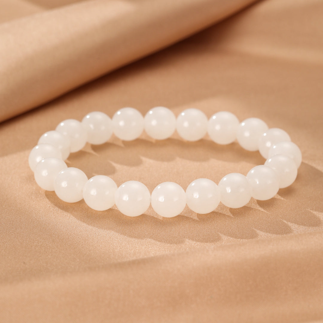 Full Measure Hetian Jade Beaded Bracelet - Simple and elegant white jade beads on a beige background.