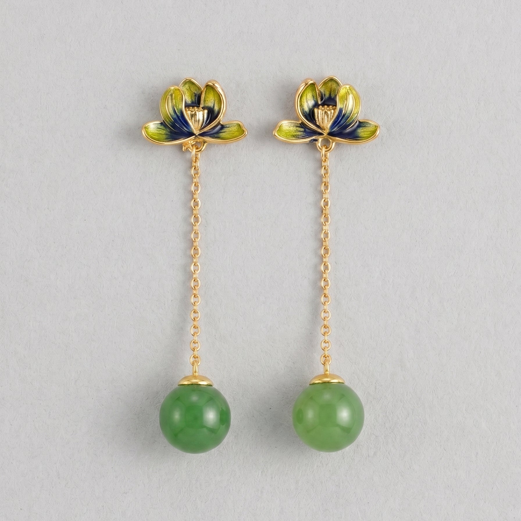 Halcyon green jade lotus drop earrings featuring delicate gold chains and vibrant green jade spheres.
