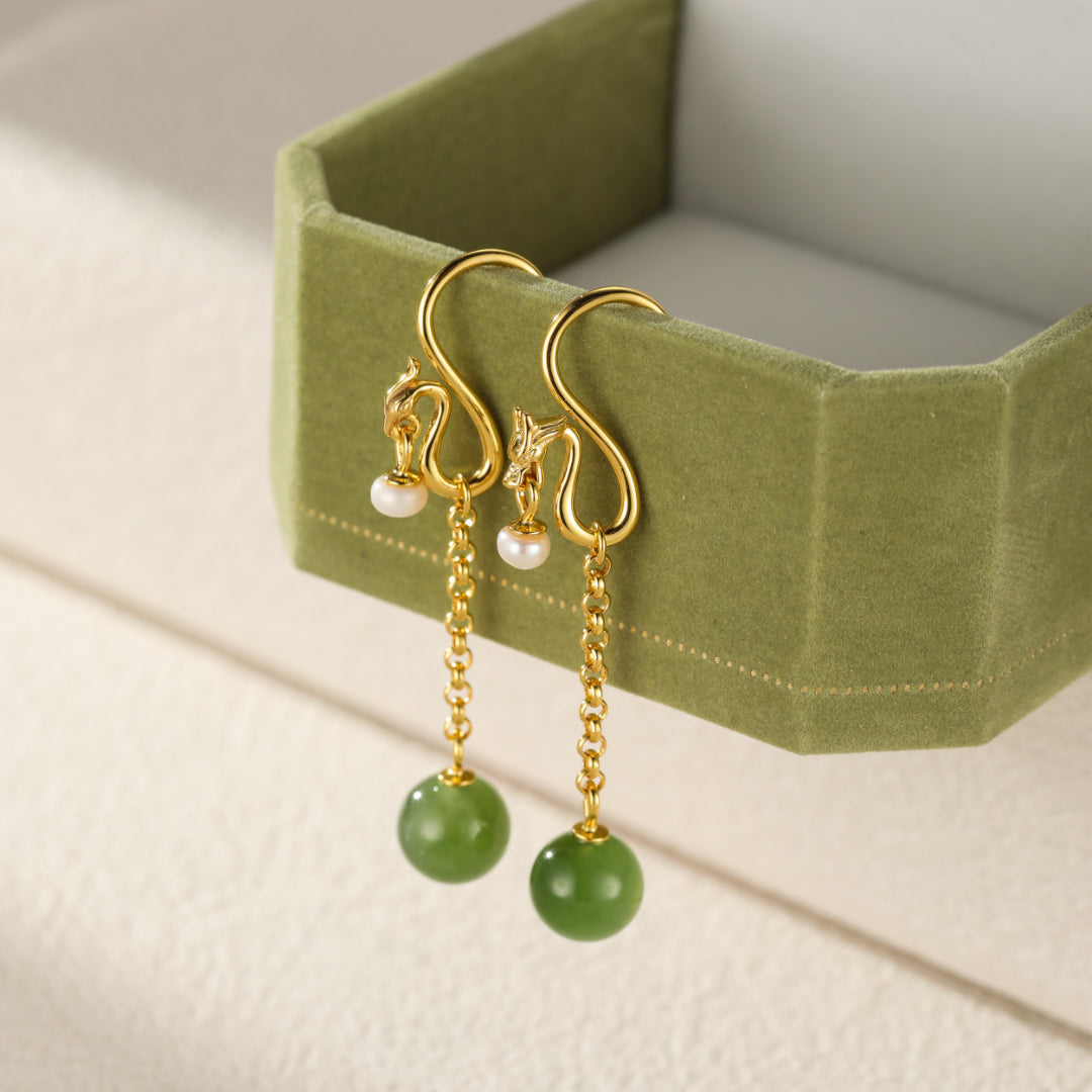 Holding Court — Green Jade Dragon Drop Earrings with a pearl accent and gold chain, showcased in a green velvet jewelry box.