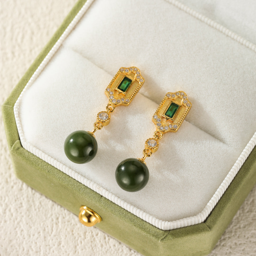 Kindred gold drop earrings with green jade spheres and emerald accents.