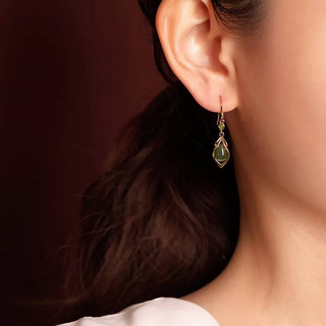 Linger green jade water drop earrings dangling from a woman's ear