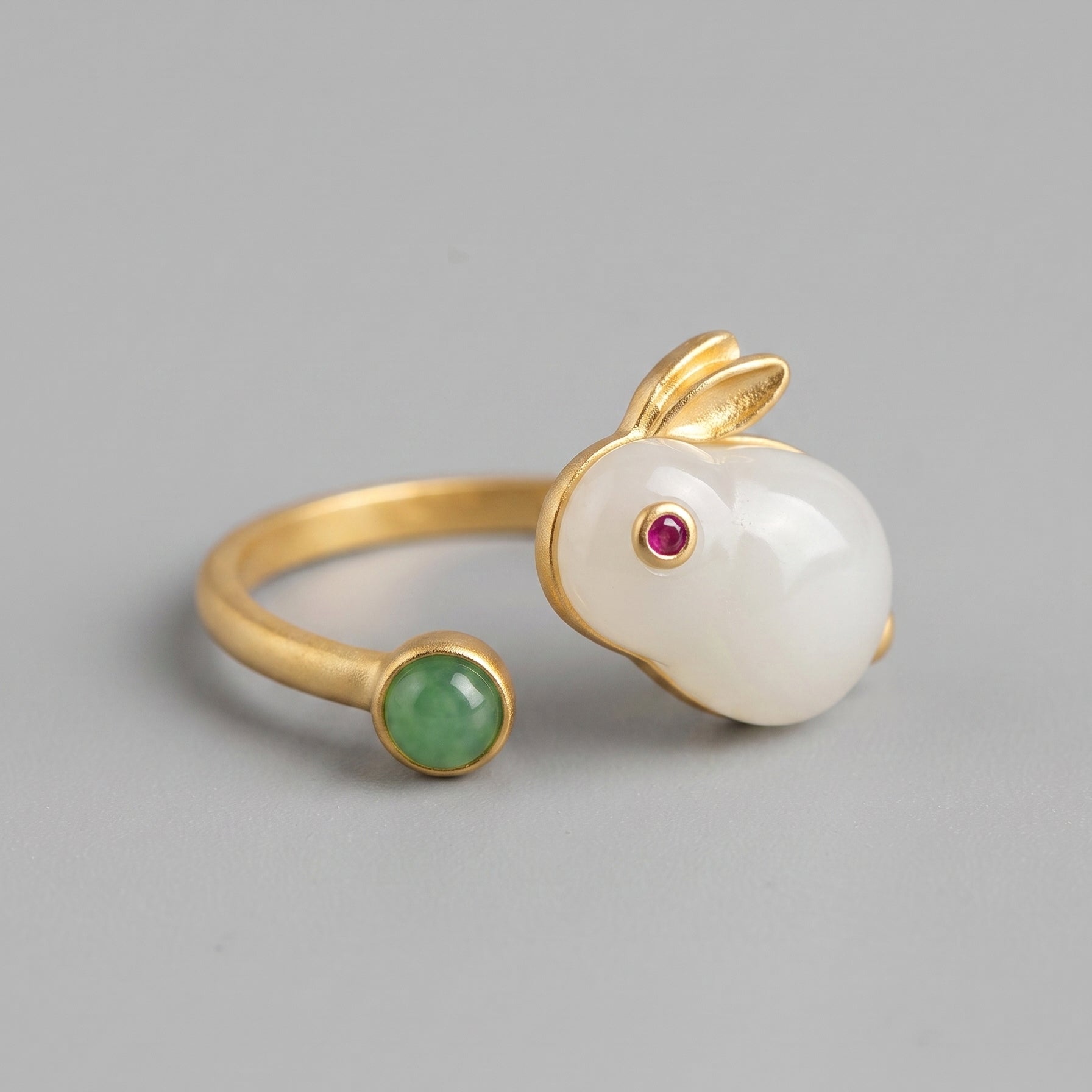 Moonglow Hetian Jade Rabbit Ring featuring a white jade rabbit with a ruby eye and a jade tail accent on a gold band.