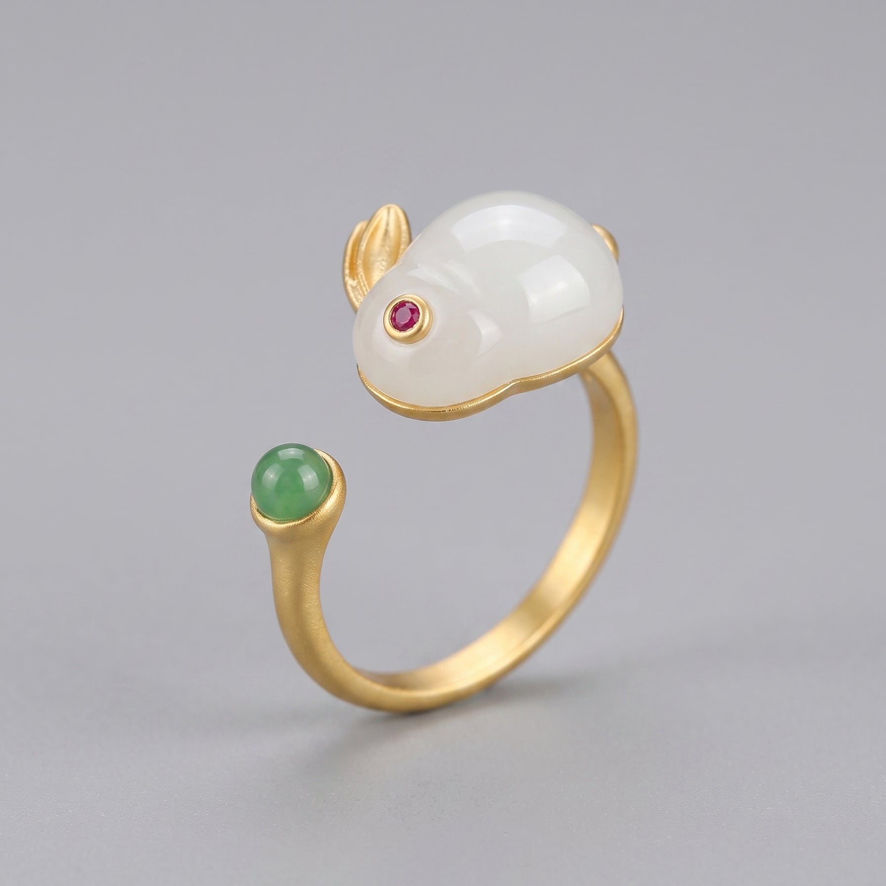 Moonglow Hetian Jade Rabbit Ring with a ruby eye and a green jade accent on a gold band.