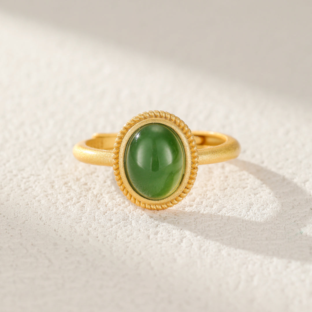 New Day ring featuring a smooth, oval, green jade cabochon set in a gold-plated silver band with a twisted rope bezel.