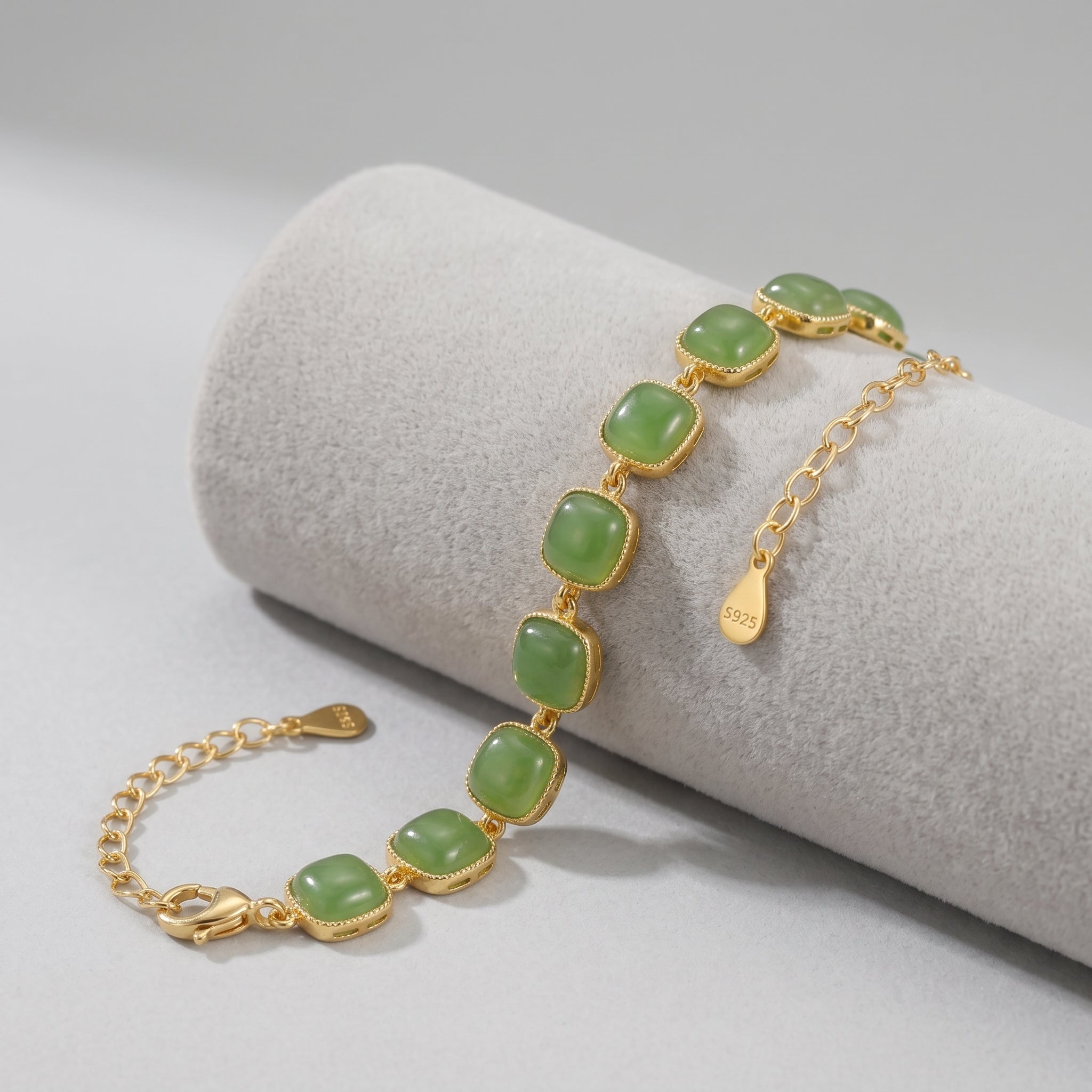 Gold chain bracelet featuring square green jade stones set in a gold-tone metal, with a lobster clasp and an adjustable extender chain marked "S925".