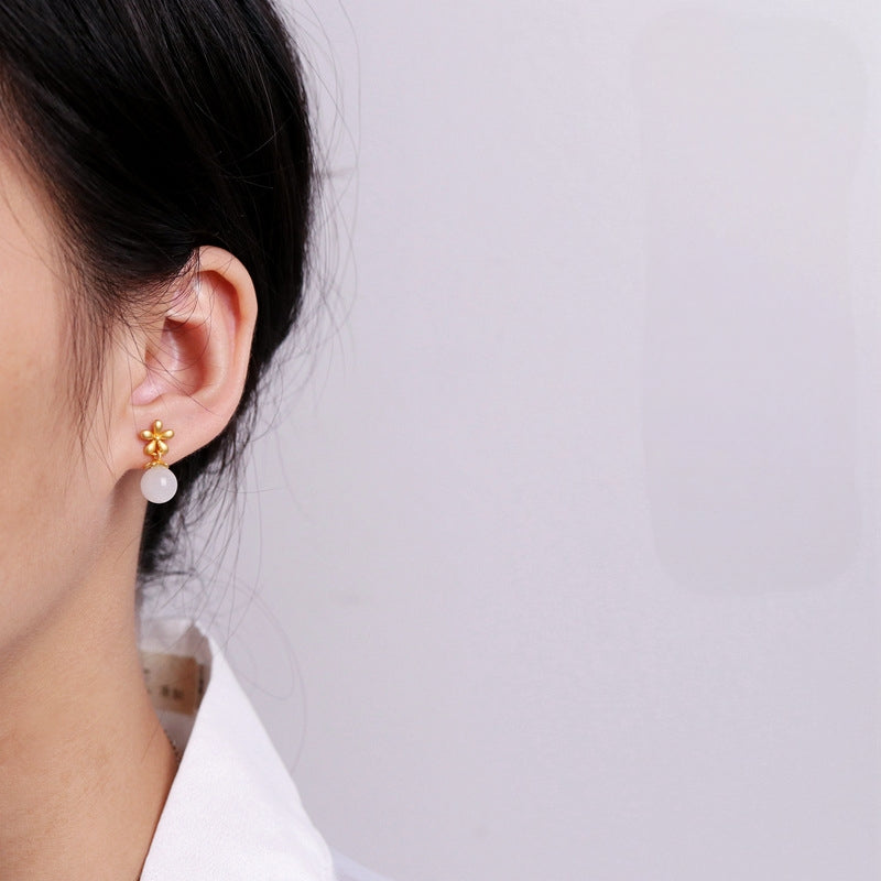Sweet Nothings Hetian Jade Flower Drop Earrings featuring a small gold flower stud with a white jade bead dangling below.