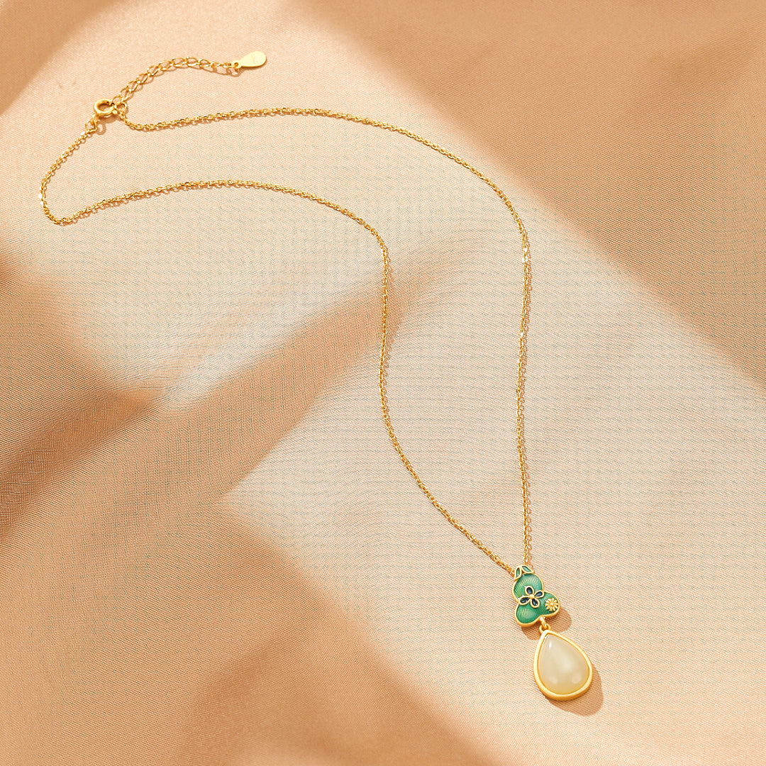 Twice Blessed Hetian Jade Gourd Jewelry Set with a gold-plated silver chain and a pendant featuring a green gourd charm and a teardrop-shaped white jade stone.